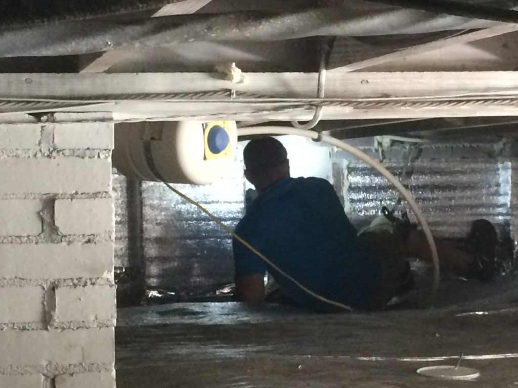 Mold inspection in a crawlspace being performed by The Solutions Group technician.