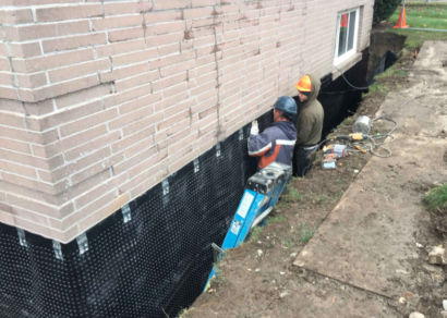 Basement waterproofing being installed on the exterior of a home in Durham, NC