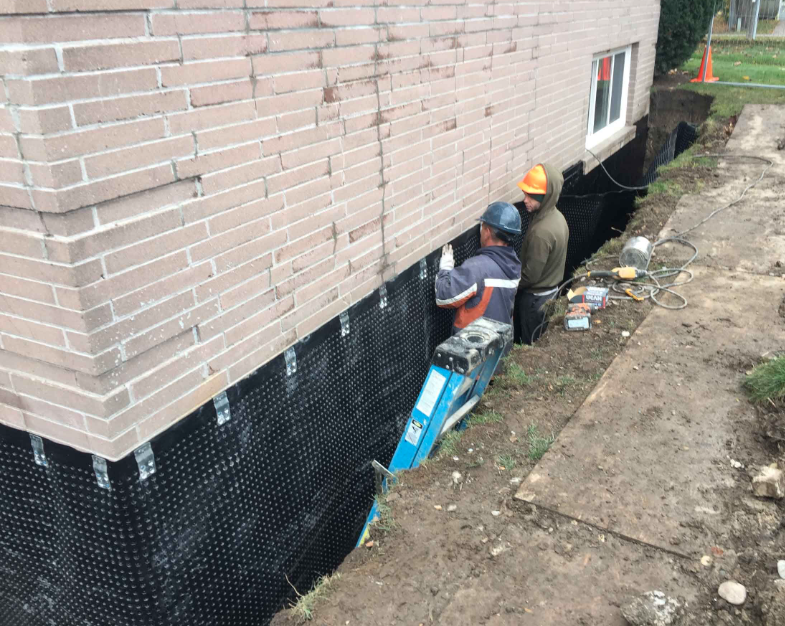 Basement waterproofing being installed on the exterior of a home in Durham, NC